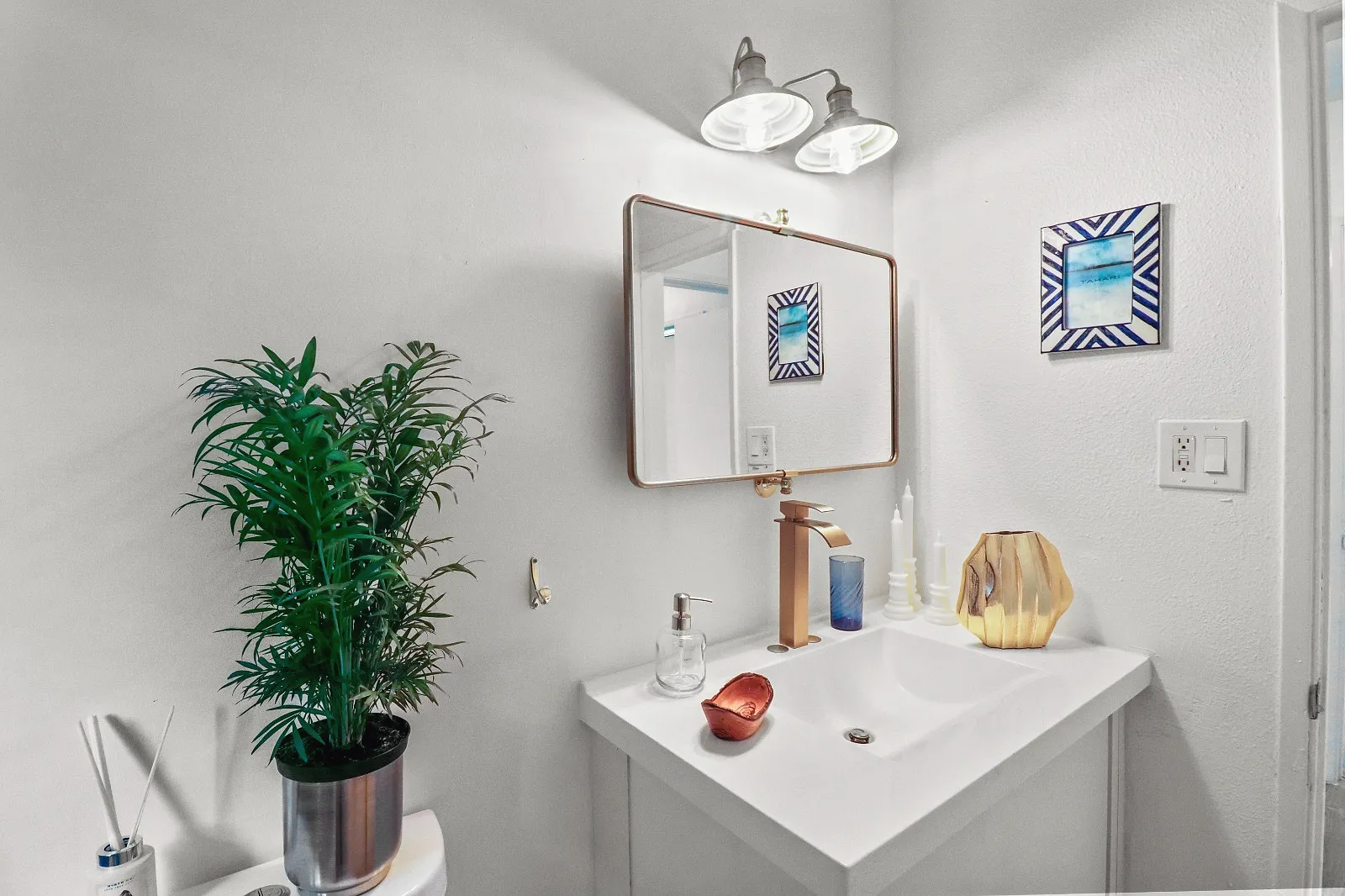 Bathroom with a white vanity, framed mirror and tiled surround