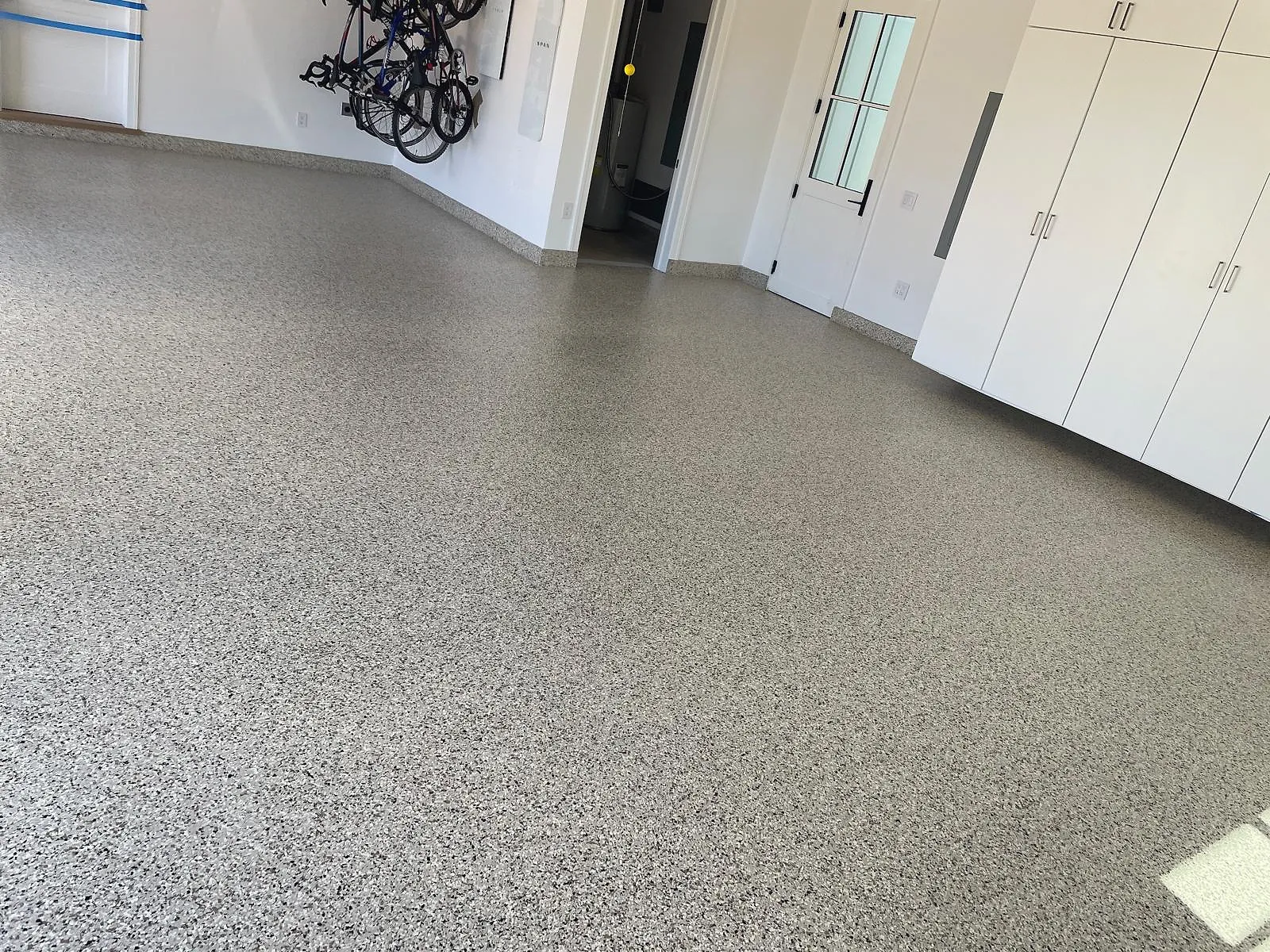 Seamless epoxy floor in a commercial space with white cabinetry along one wall