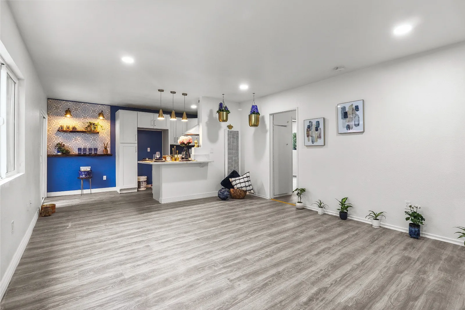 Wide view of a completed open-plan kitchen and living area with recessed lighting