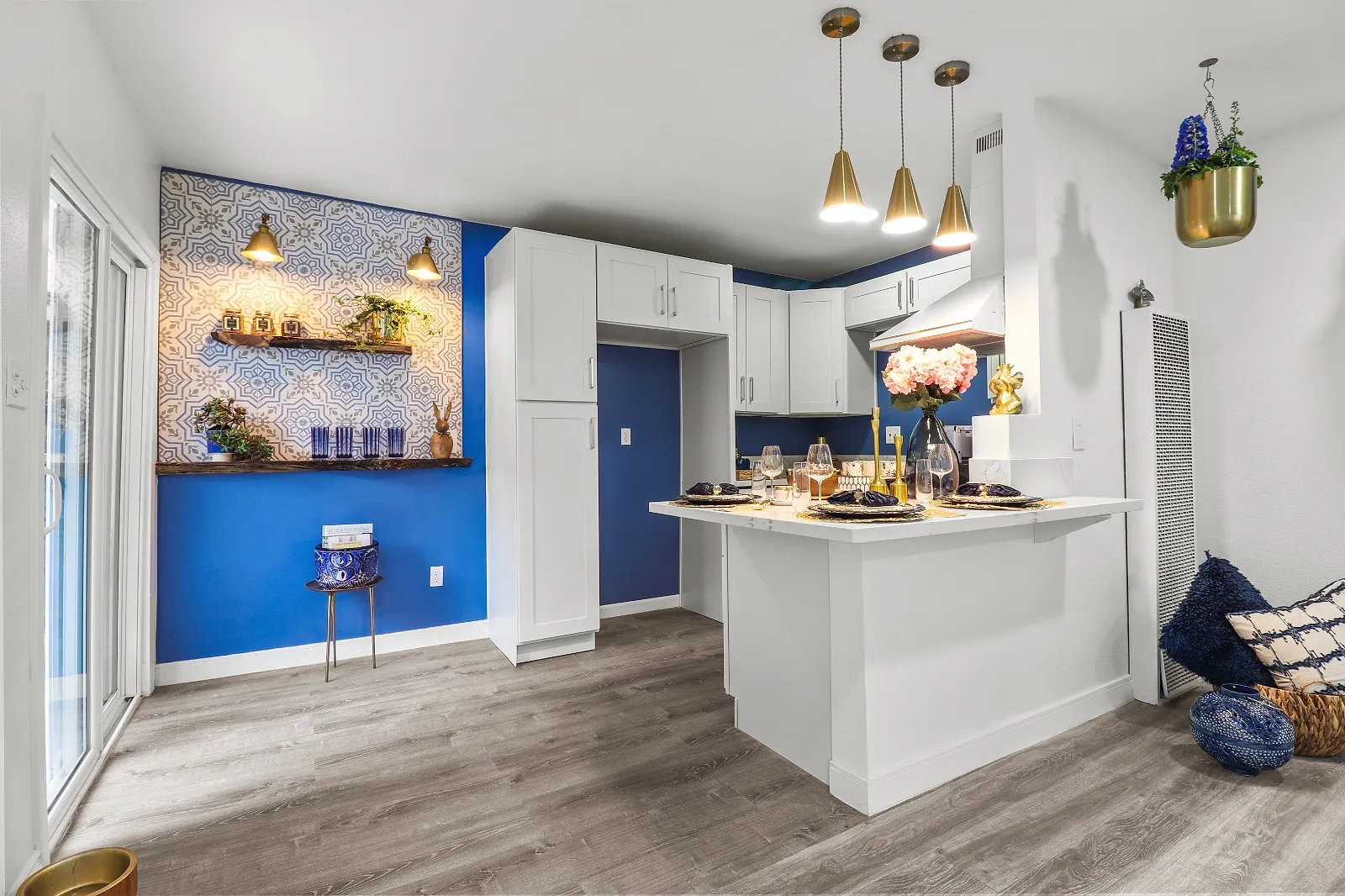 Kitchen island with brass pendant lighting above a quartz worktop